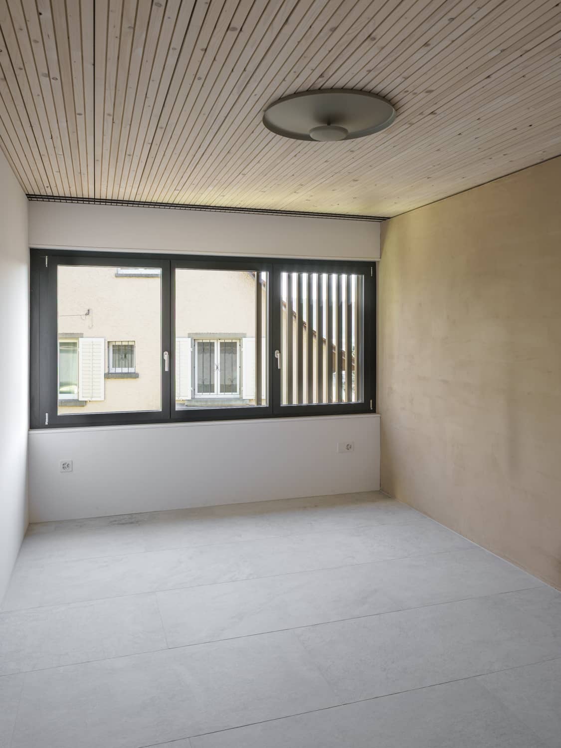 In einem Raum mit Holzdecke h&auml;ngt eine stilvolle Deckenleuchte